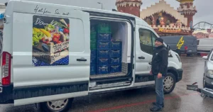 Ein Fahrer der Münchner Tafel ladet nach dem Oktoberfest Kisten mit übrig gebliebenem Gemüse, Obst und Fleischwaren aus Kufflers Weinzelt und Poschners Hähnchenbraterei auf einen LKW.